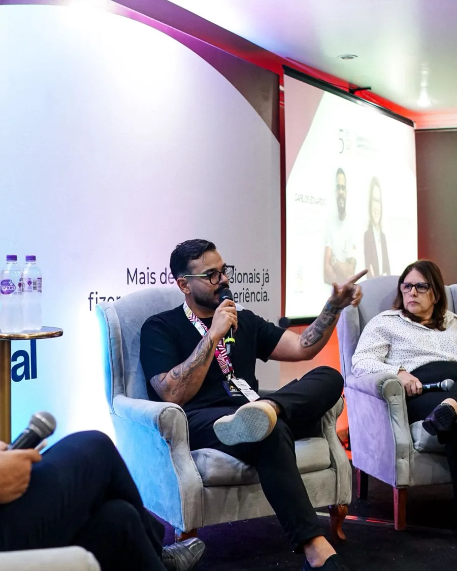 Carlos Eduardo falando ao microfone em um painel de evento do setor condominial em São Paulo