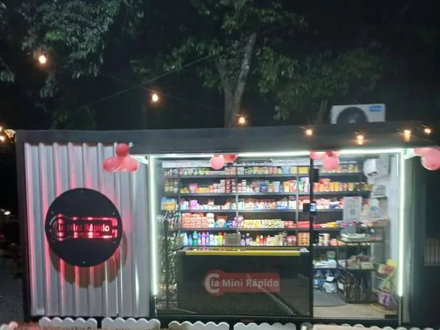 Mini mercado autônomo instalado em contêiner na área comum do condomínio, iluminado à noite